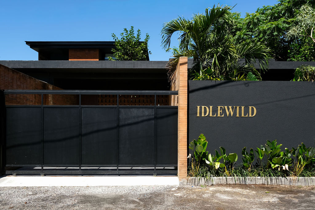 IDLEWILD gate and facade with brass signage, viewed from the street